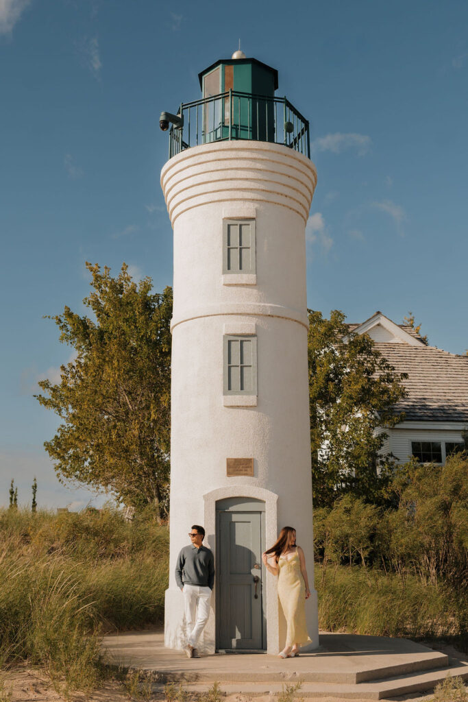 Editorial style couples photos in front of Robert H. Manning Memorial Lighthouse on Empire Beach.