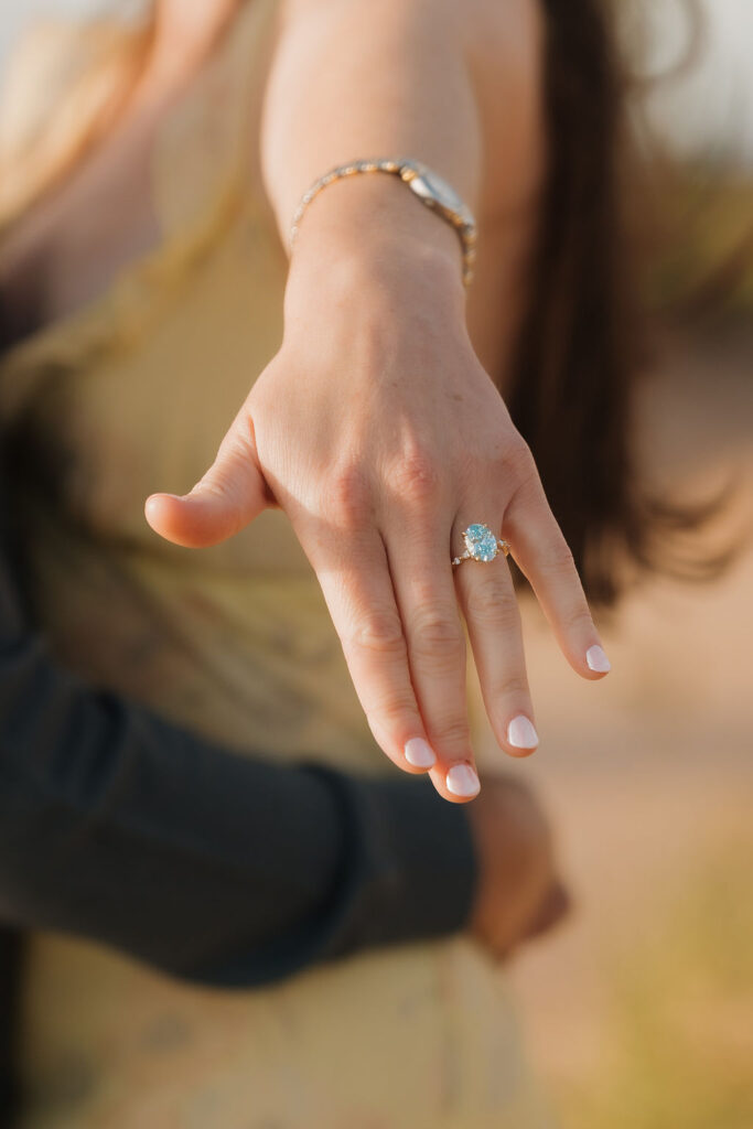 Woman showing off her engagement ring after her Sleeping Bear Dunes proposal.