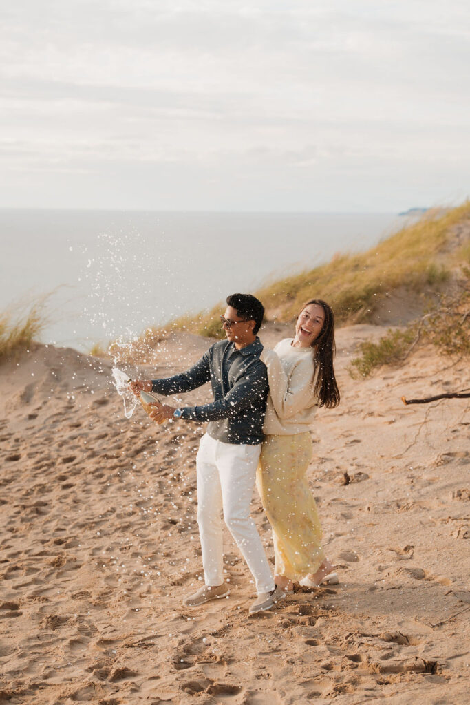 Couple popping champagne at Pierce Stocking Scenic Drive after their proposal.