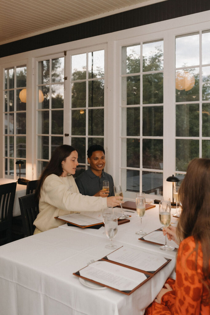 Couple celebrating their proposal with family at The Riverside Inn in Leland, Michigan.