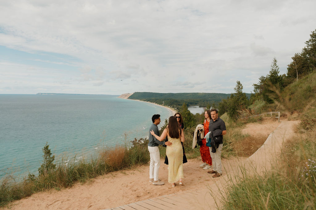 Couple celebrating with family at Empire Bluff after their surprise proposal at Sleeping Bear Dunes National Lakeshore.