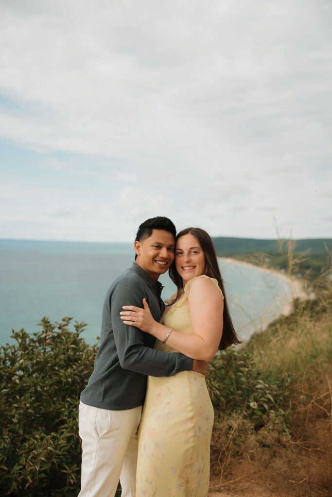 Couple holding each other after their Sleeping Bear Dunes proposal at Empire Bluff.