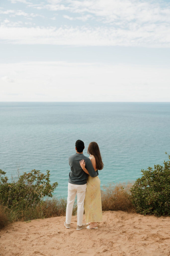 Couple admiring Lake Michigan after their Sleeping Bear Dunes proposal at Empire Bluff.