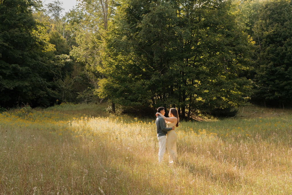Couple posing in a field during golden hour