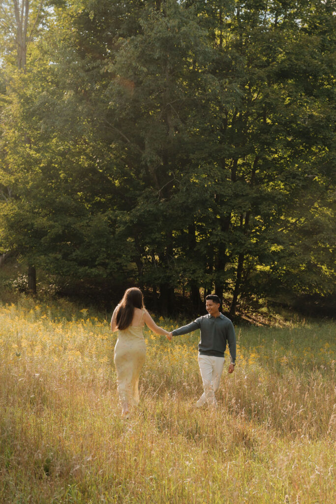 Couple dancing in a field at Empire Bluff during golden hour