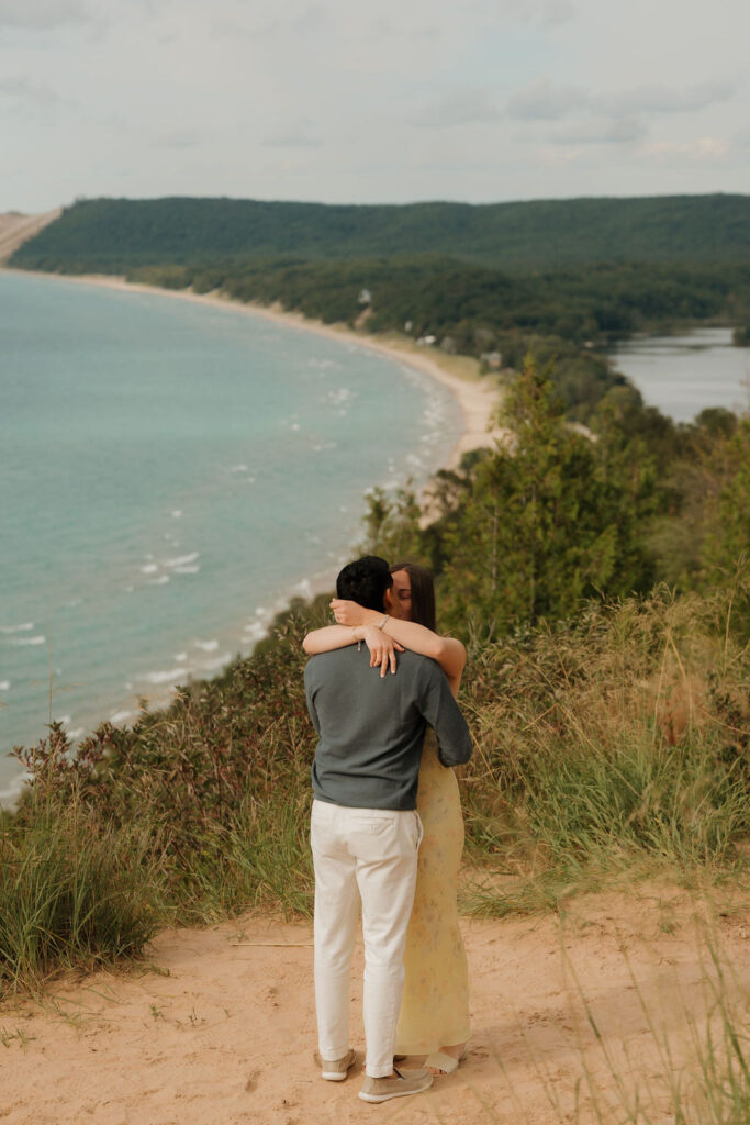 Couple kissing after their Sleeping Bear Dunes proposal at Empire Bluff.