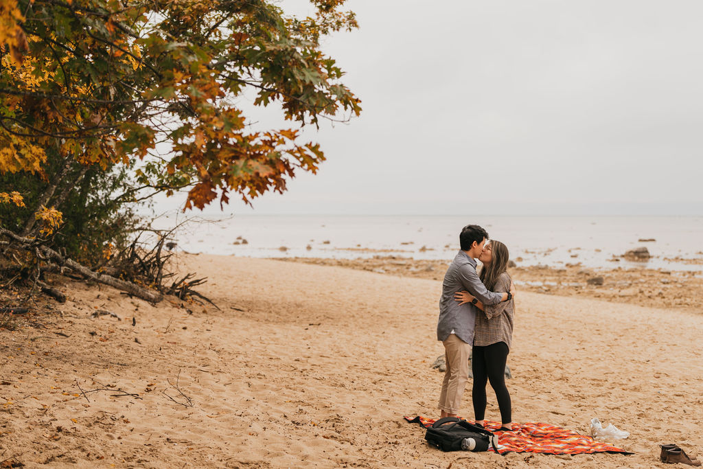 Couple kissing after their Traverse City Michigan proposal at Old Mission Lighthouse.
