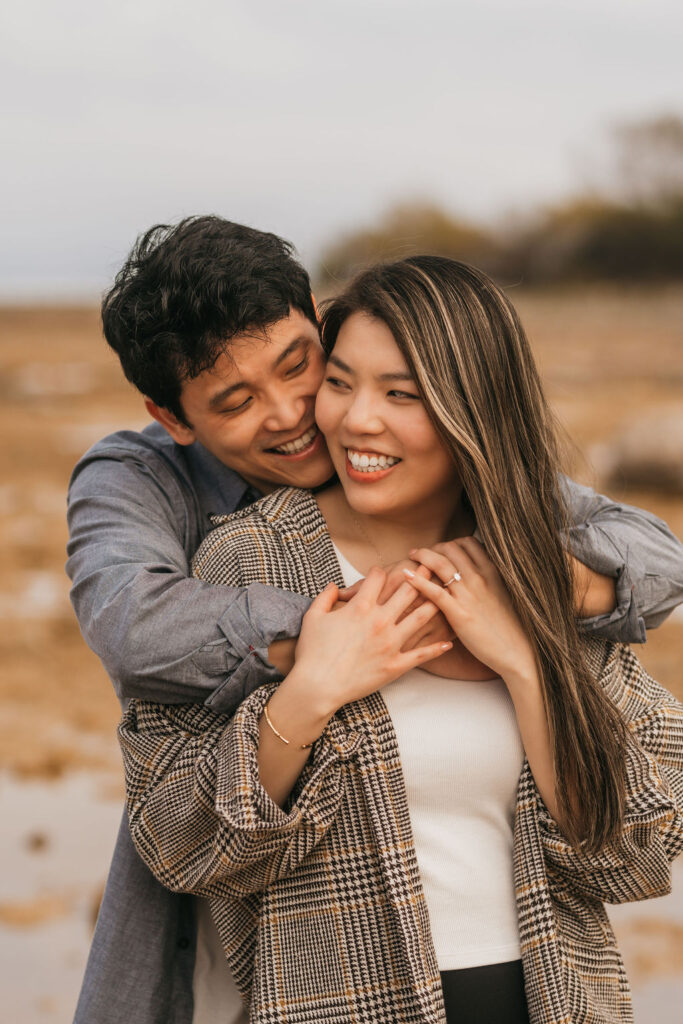 Couple playfully posing on the beach for their Traverse City Michigan proposal photos.