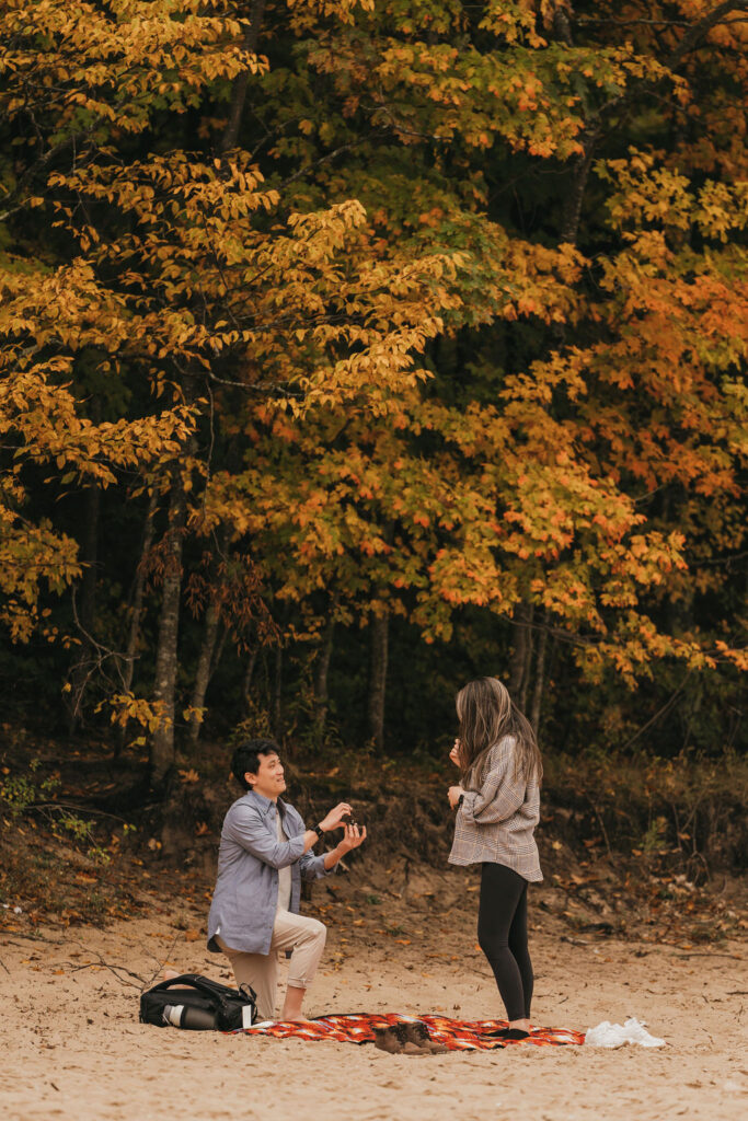 Man proposing during a Traverse City Michigan proposal at Old Mission Lighthouse during the fall.