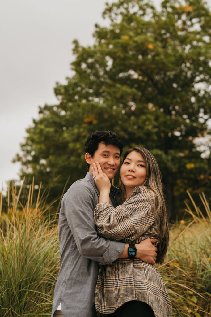 Couple posing in the tall beach grass in Traverse City Michigan.