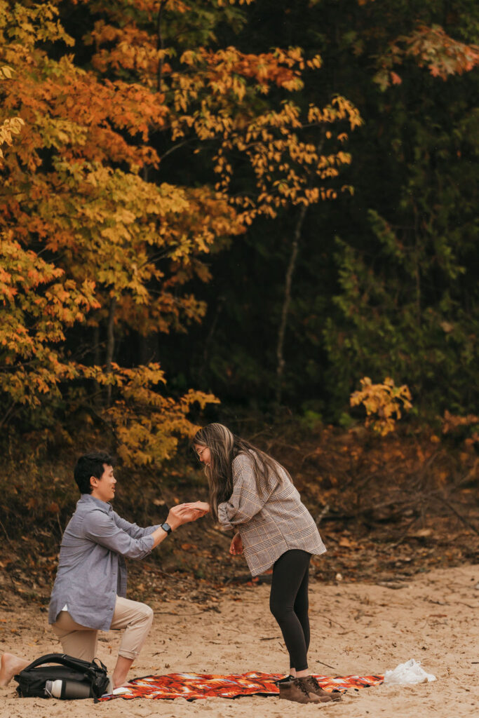 Man proposing during a Traverse City Michigan proposal at Old Mission Lighthouse during the fall.