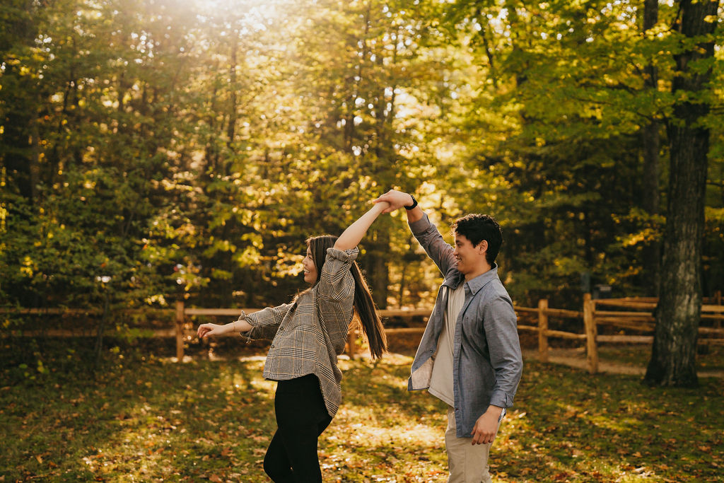 Couple dancing during their dreamy fall proposal photos in Traverse City Michigan at Old Mission Lighthouse