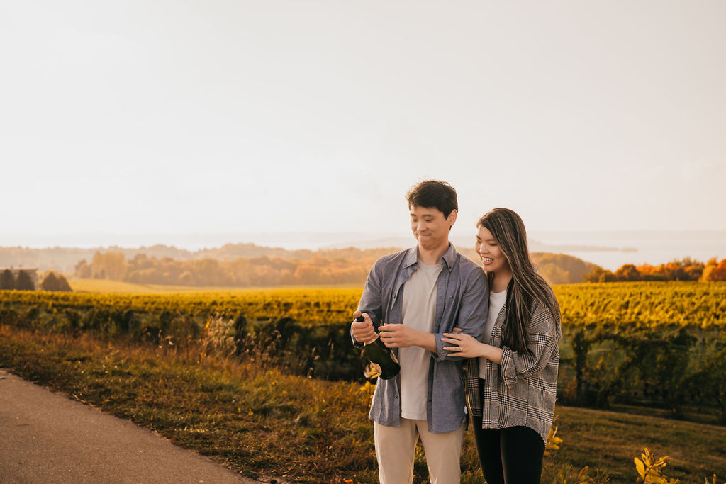 Couple popping champagne during golden hour at The Overlook for their Traverse City Michigan proposal.