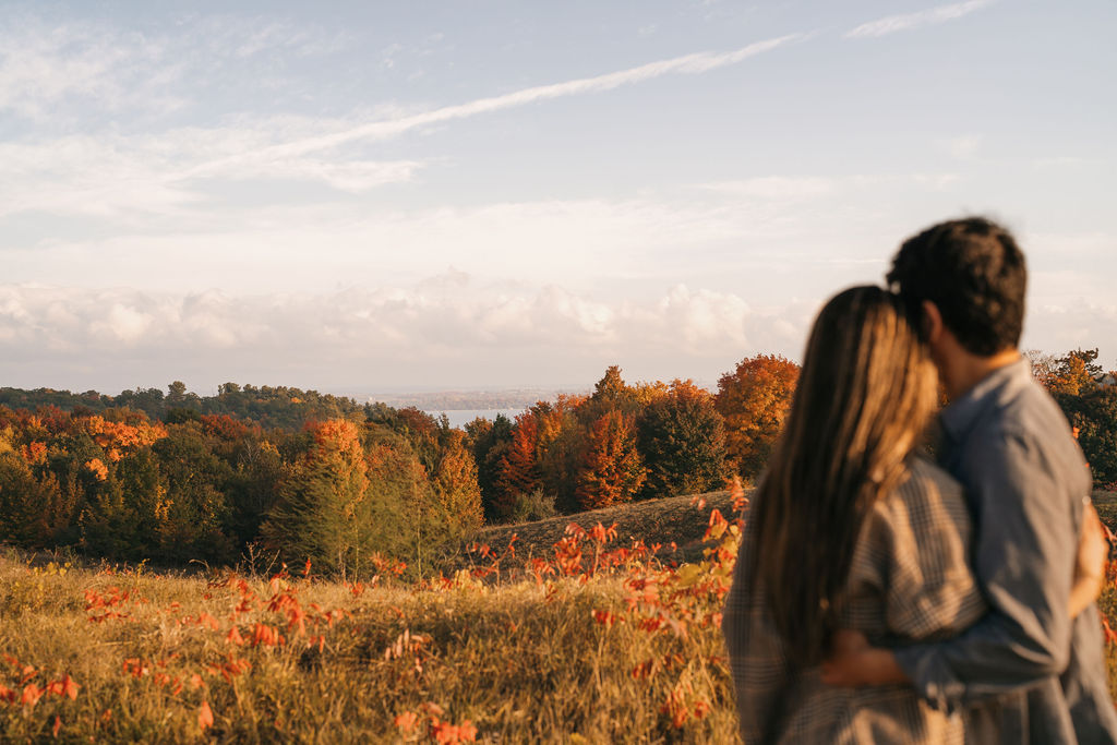 Couple admiring the fall colors and trees at The Overlook during their Traverse City Michigan proposal photos.