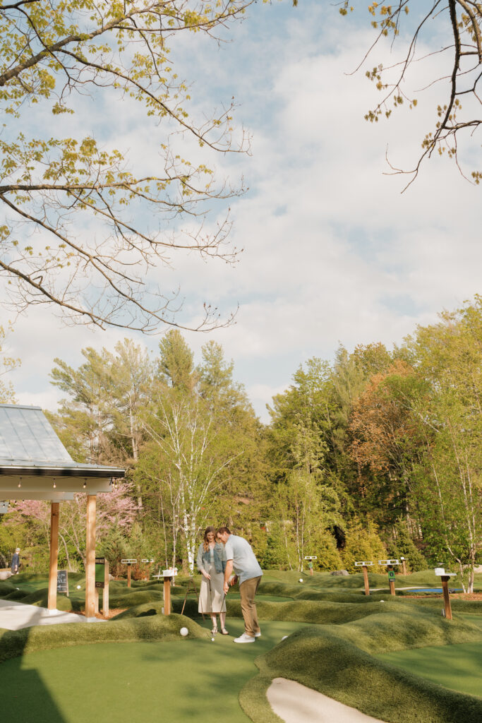 couple enjoying the sun and mini-golfing at the river club glen arbor