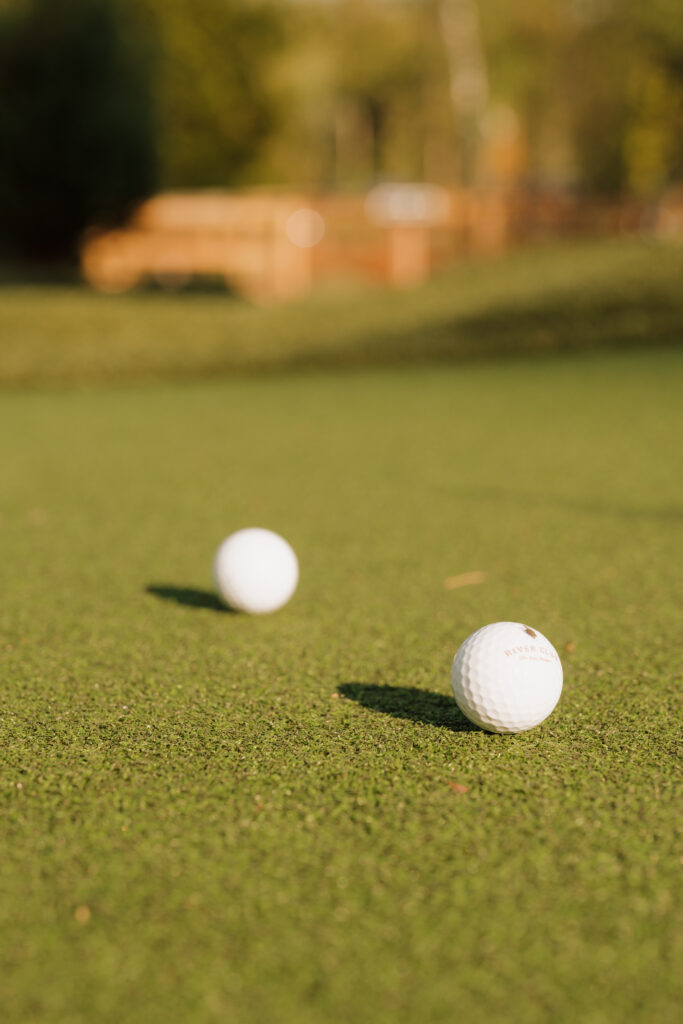 two golf balls on the green at mini-golfing during michigan engagement session