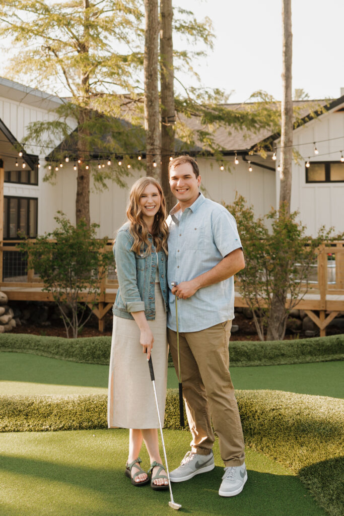 couple posing and smiling at the camera during an engagement session at the river club