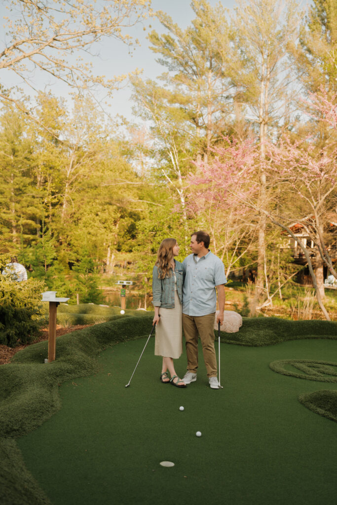 engaged couple in michigan mini-golfing at the river club glen arbor