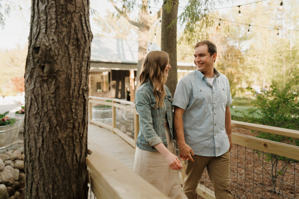 engaged couple walking through the greenery in Michigan