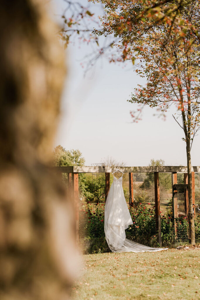 bridal gown hung outside before wedding while bride is getting ready 