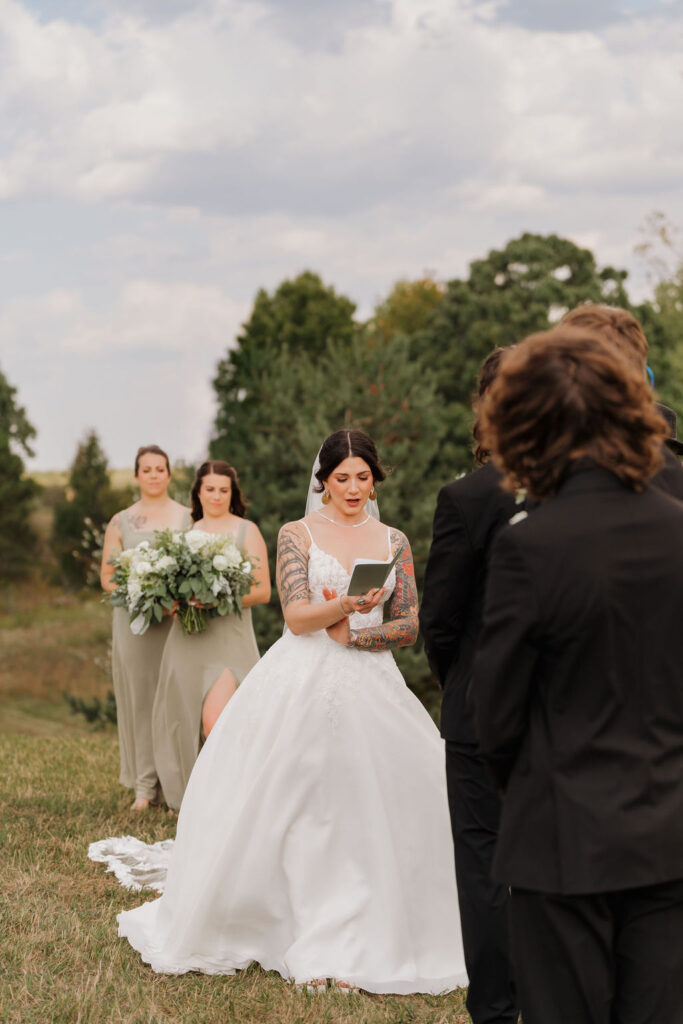 wife saying her vows to her groom at their wedding in the hills of michigan
