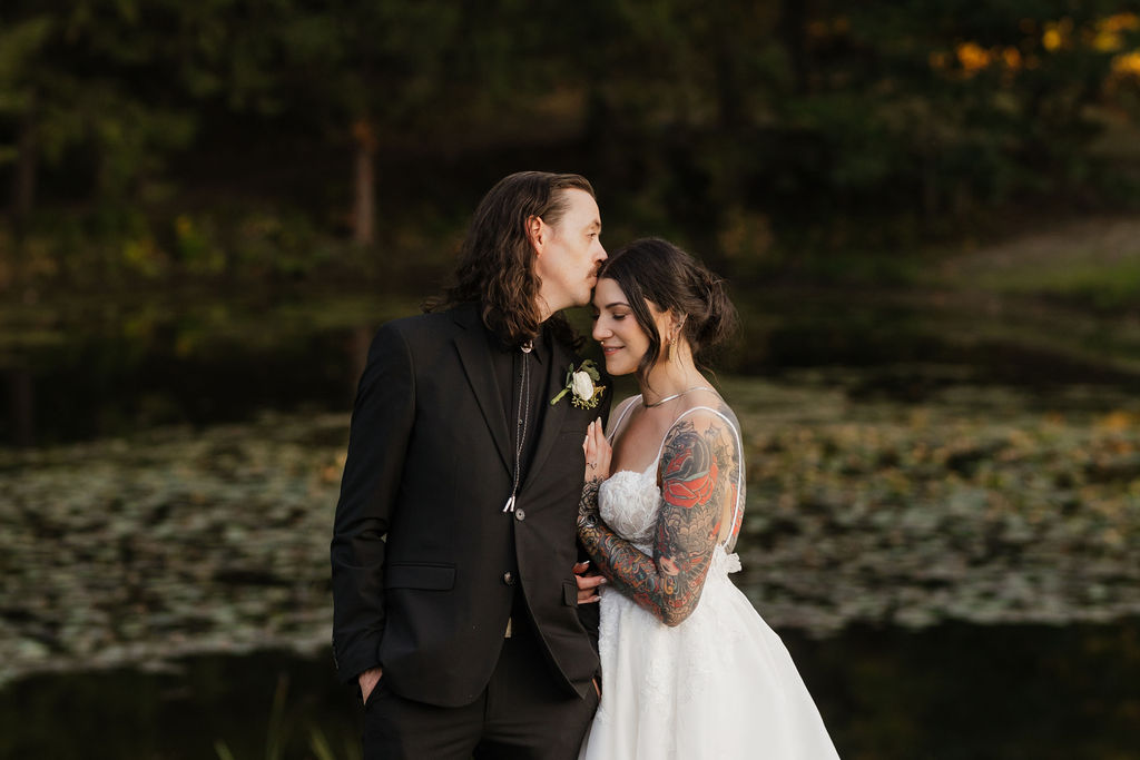 groom kissing bride on the forehead at their intimate wedding 