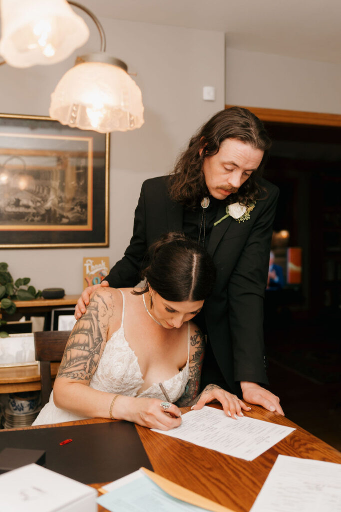 bride and groom signing their marriage certificate
