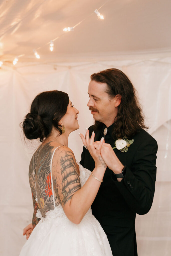 the first dance of the bride and groom at their wedding reception in mi