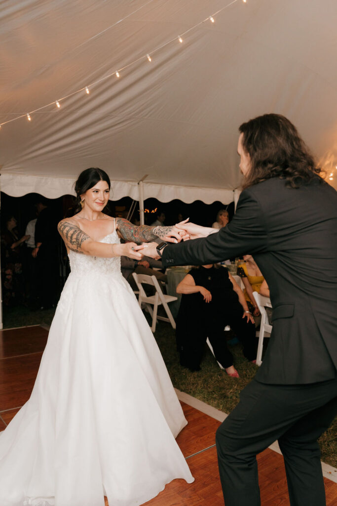 bride and groom having fun during their first dance at their micro-wedding reception with close family