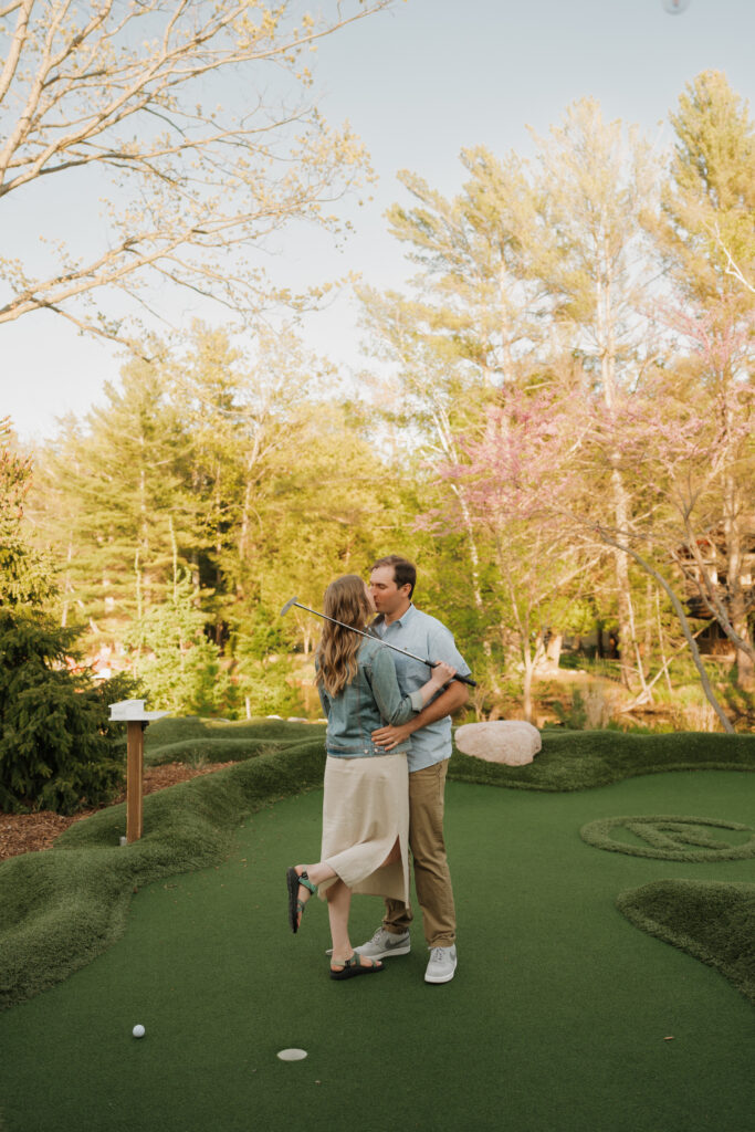 mini golfing during an engagement session at River Club in Glen Arbor, Michigan