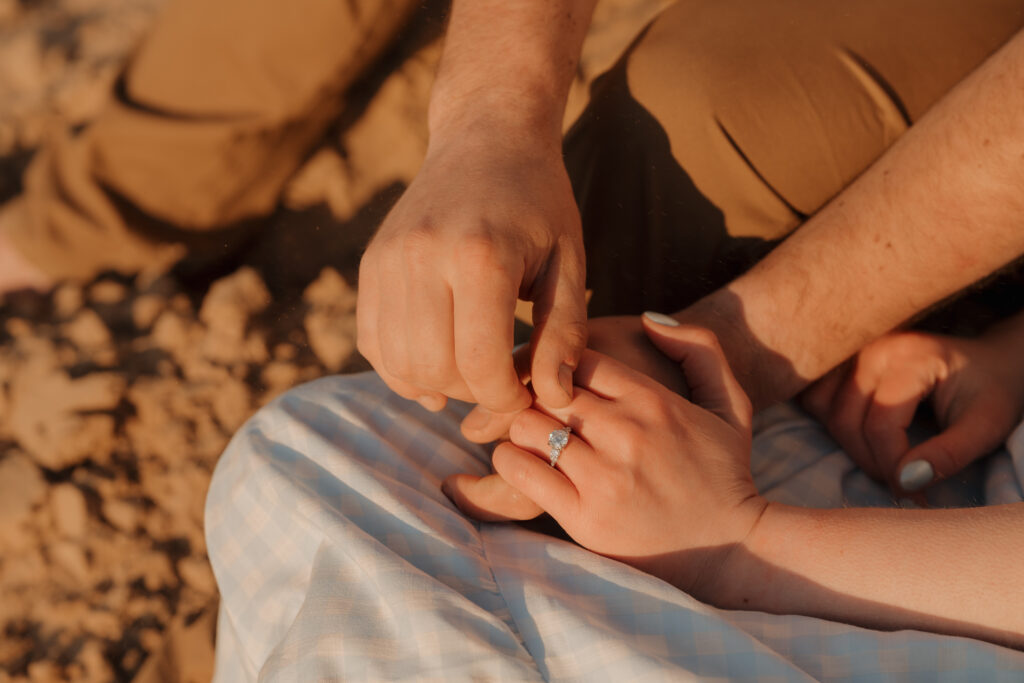 bride and groom holding hands and showcasing their engagement rings