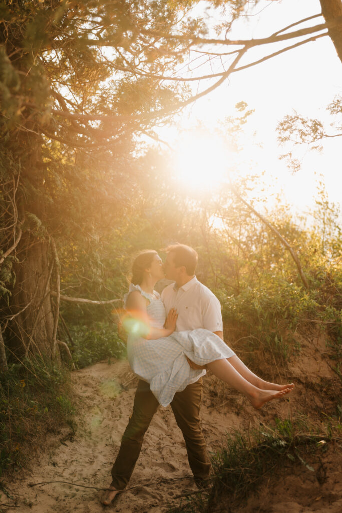 groom holding bride and sharing a romantic kiss at sleeping bear dunes